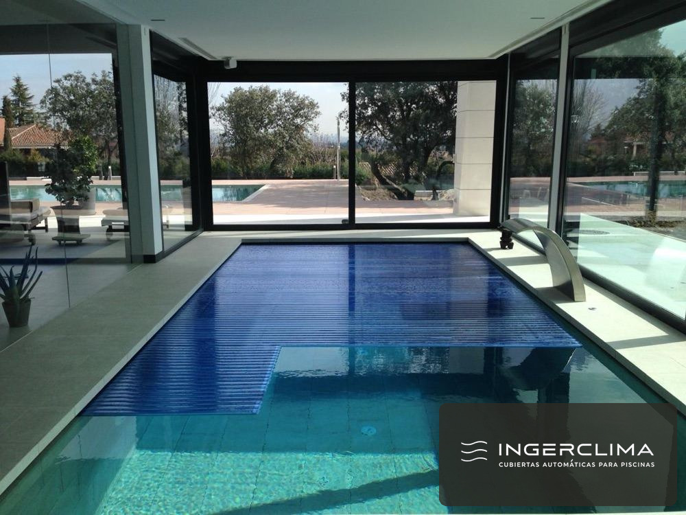 Cubierta de lamas integrada en el borde de una piscina con pavimento de piedra