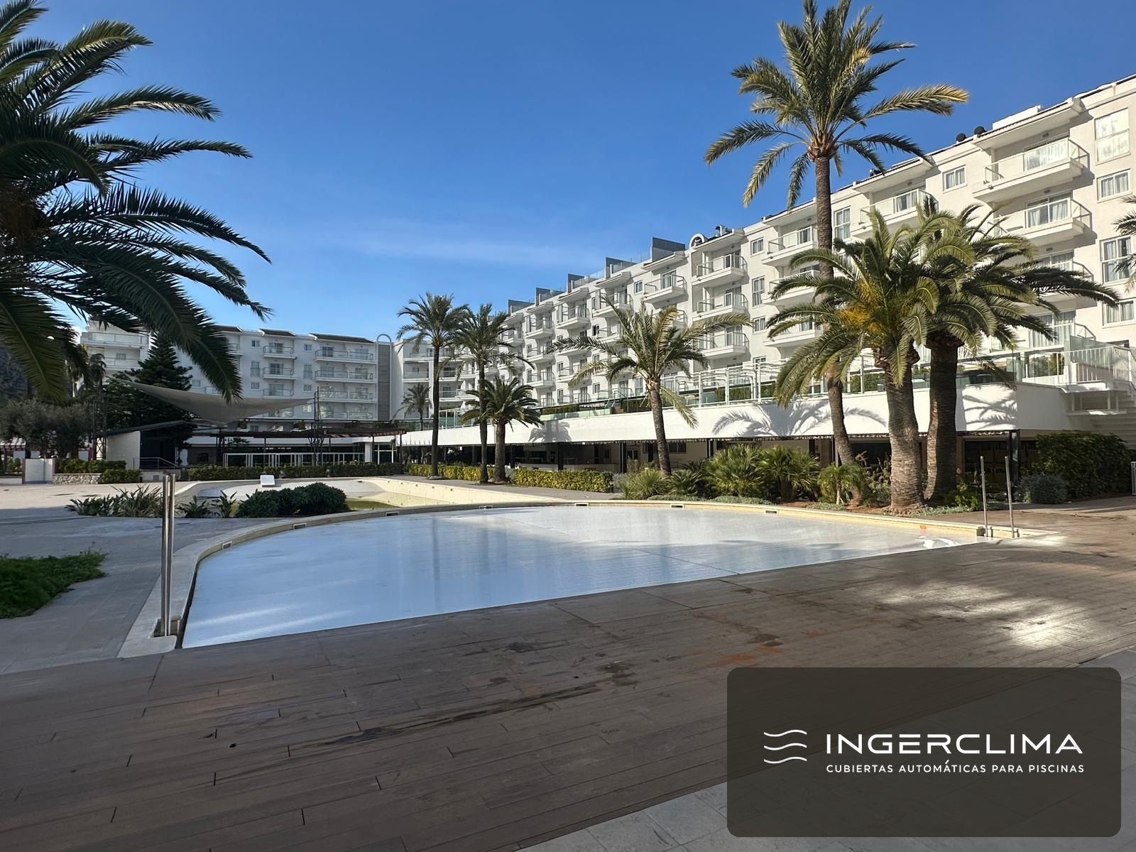 Automatic white slatted cover over the pool of an apartment complex