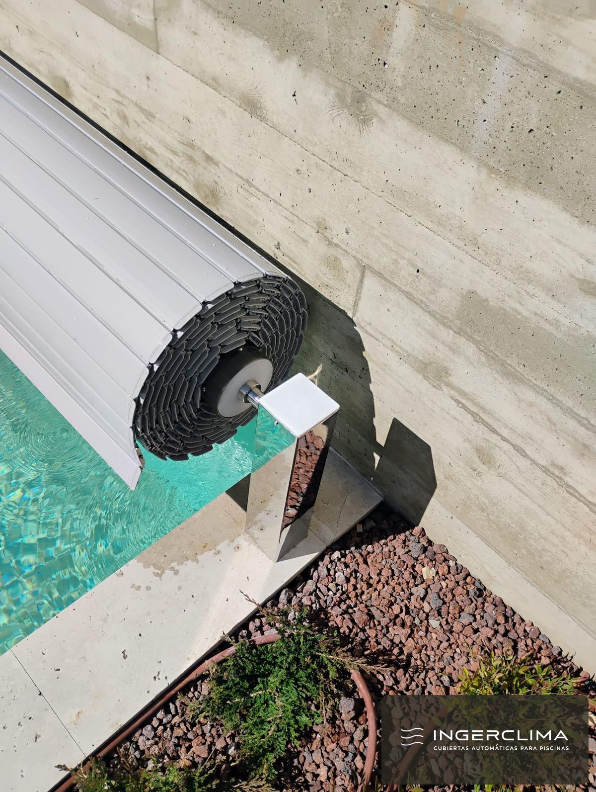 Cubierta automática de lamas abierta y recogida sobre el eje en el borde de la piscina