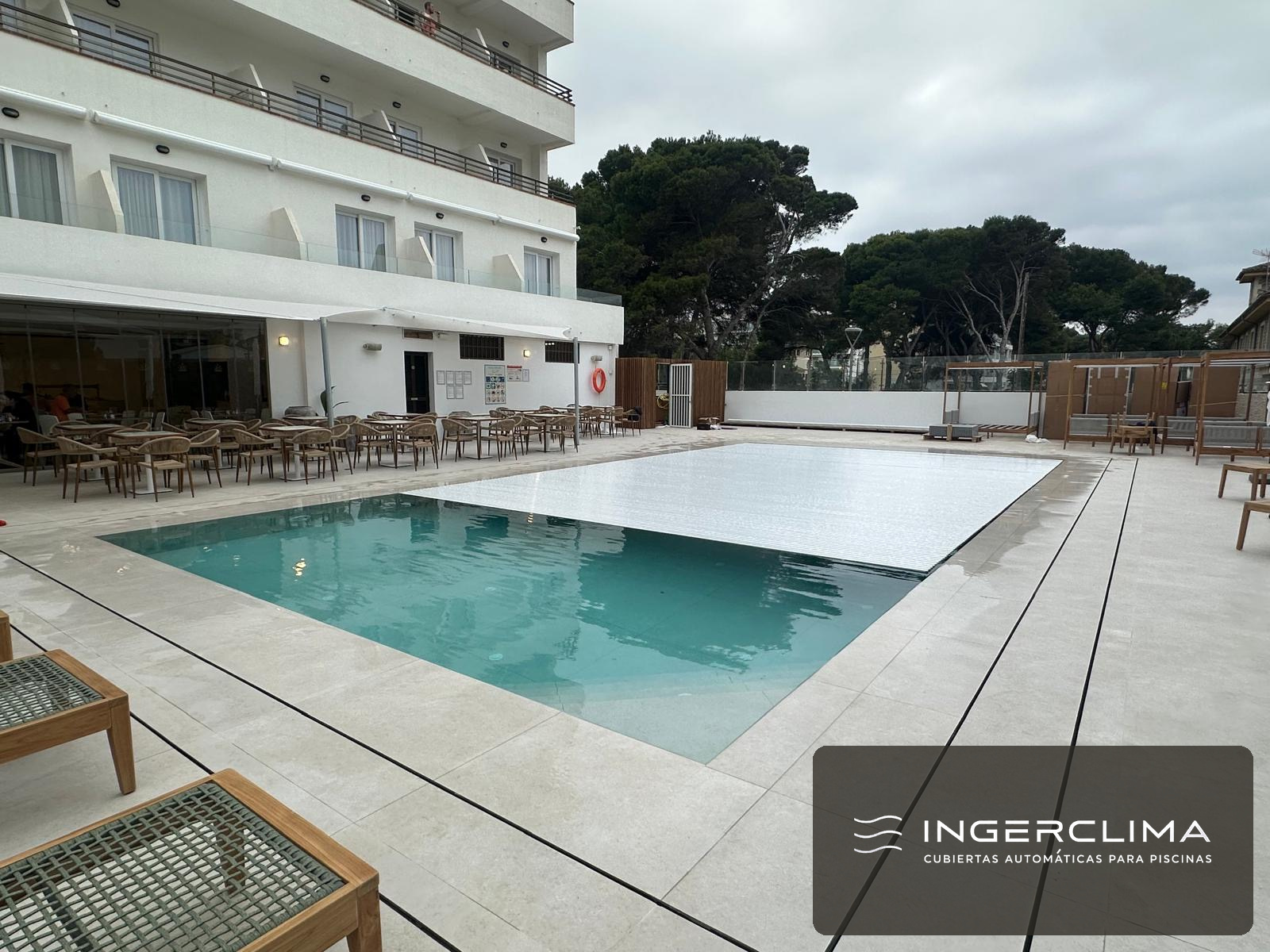Hotel pool fully closed under an automatic white slatted cover
