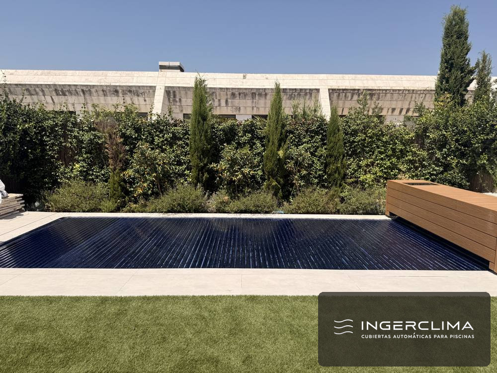 Cubierta automática recogida sobre el eje en el borde de una piscina de jardín