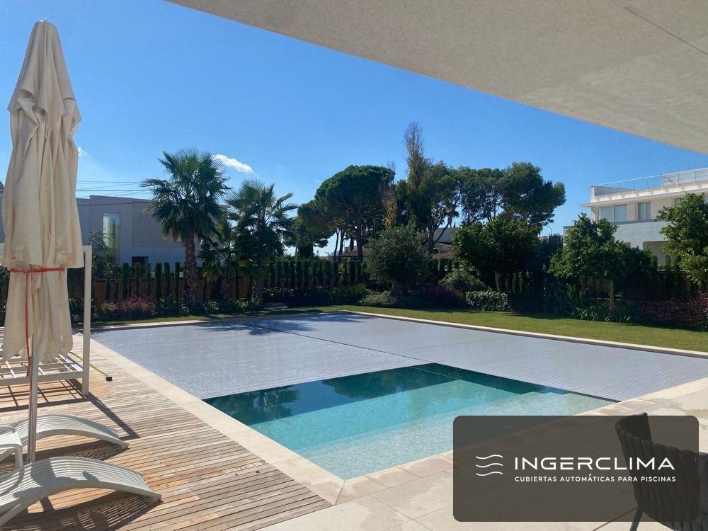 Automatic pool cover installation in a resort-style garden