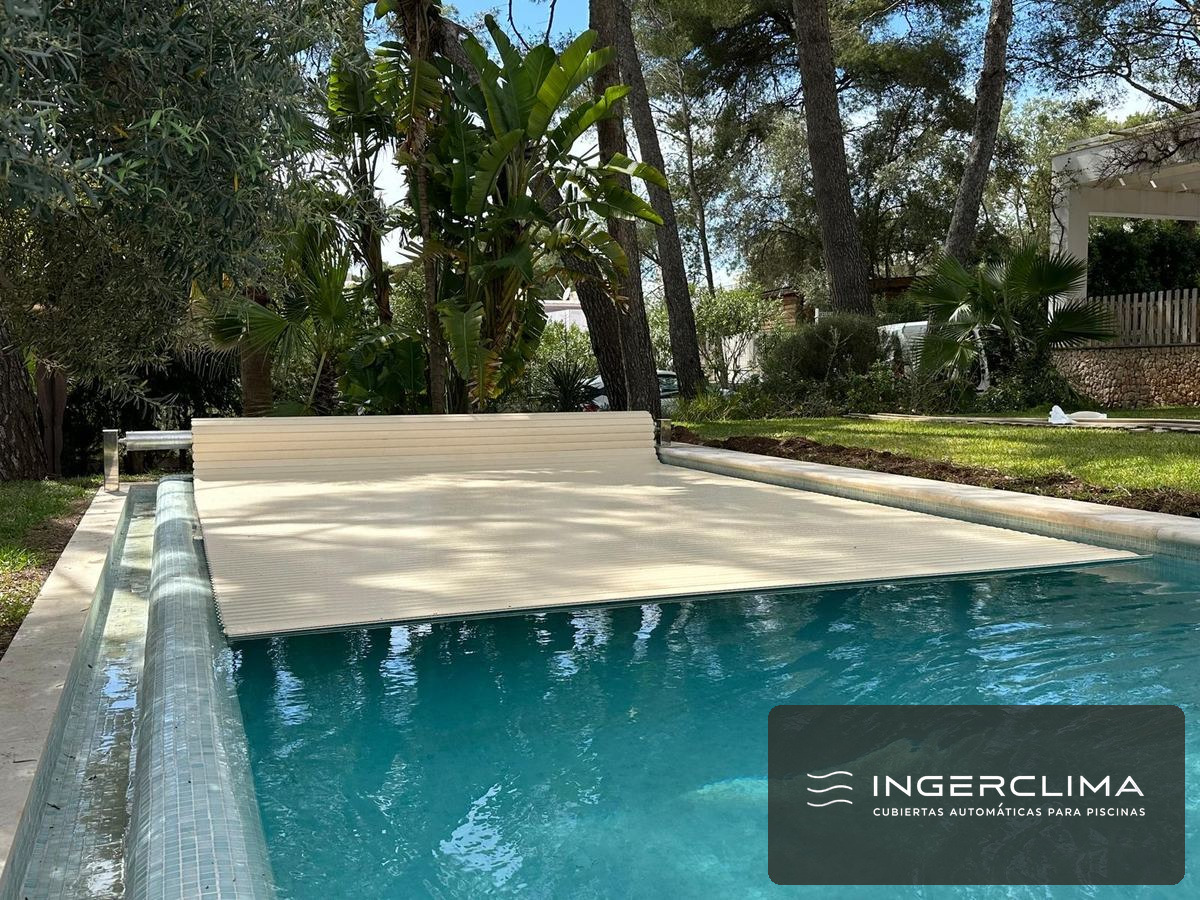 Piscina de vivienda unifamiliar con la cubierta automática de lamas a medio cerrar