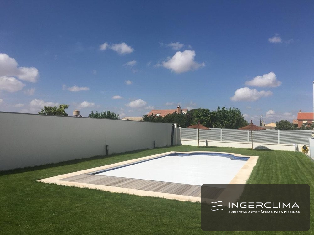 Cubierta de lamas cerrada sobre una piscina rectangular de jardín