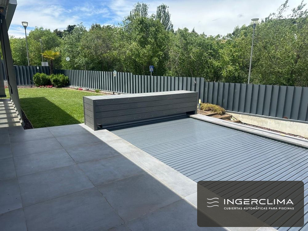 Cubierta automática de lamas cerrada sobre una piscina rectangular de jardín privado