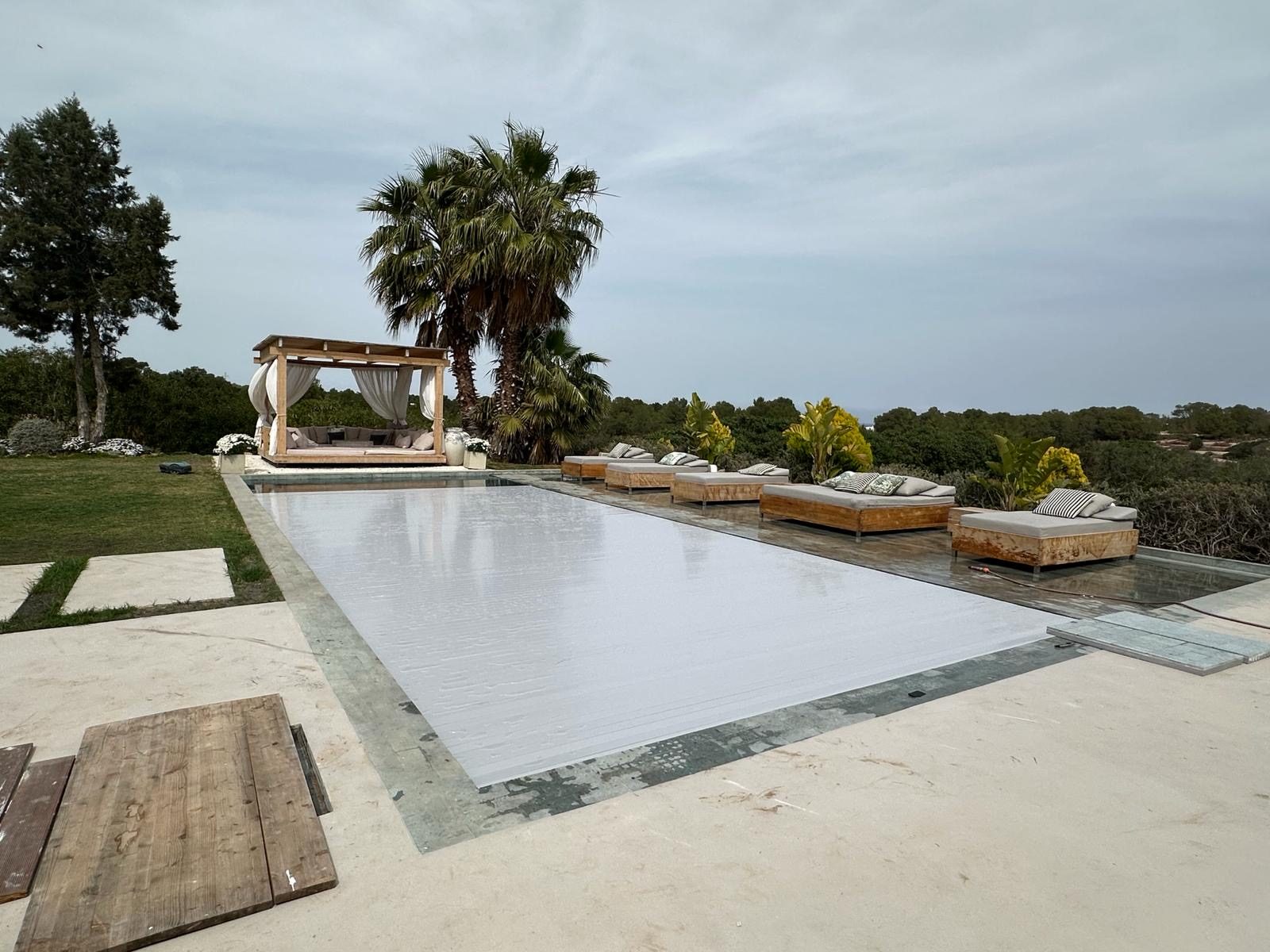 Cubierta automática de lamas blancas cerrada sobre una piscina grande de villa en Tenerife