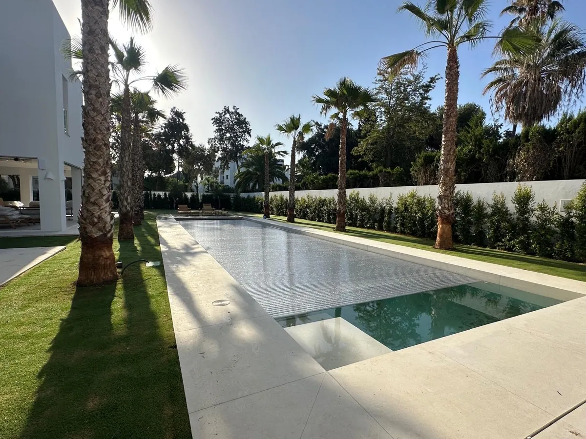 Cubierta de policarbonato solar platinum semiabierta en una piscina de diseño en Sotogrande, Cádiz, instalada por Ingerclima junto a Construcciones y Promociones Quirós